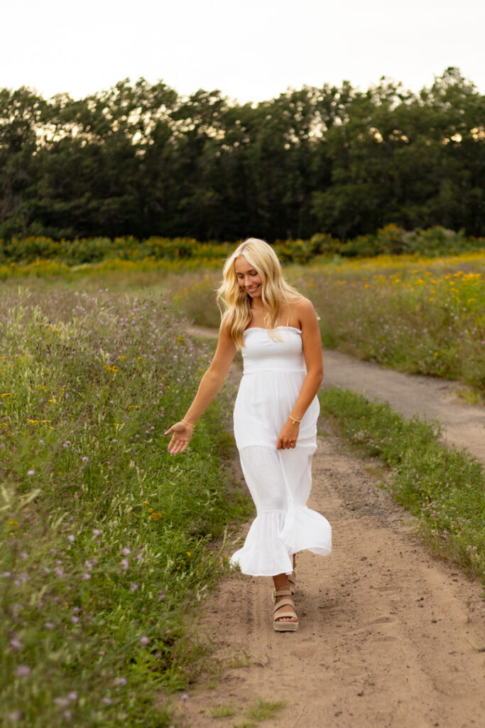 Senior photo outfit tips – white sundress for outdoor session in wildflower field