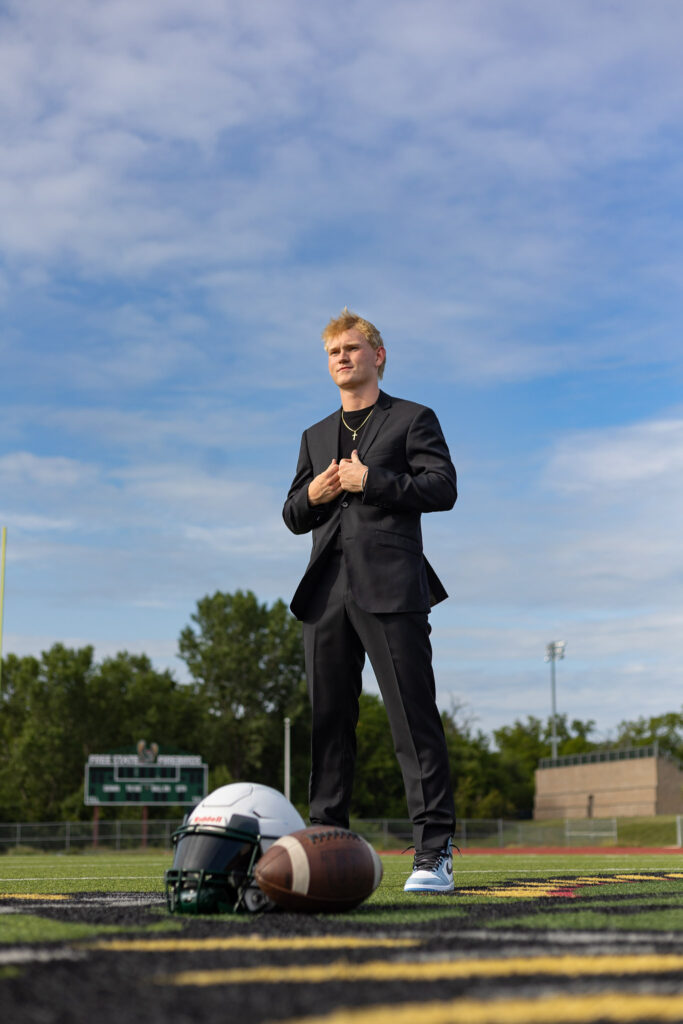 What to wear for senior pictures male athlete in formal suit with football