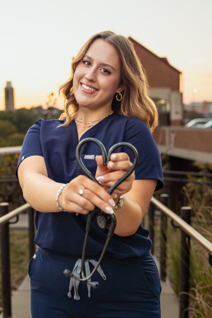 University of Kansas campus senior photos, Free State senior wearing blue nursing scrubs with stethoscope and KU pendant