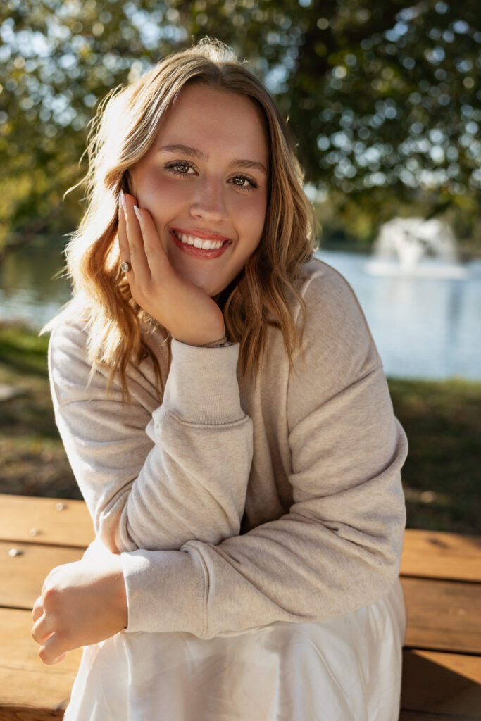 Lawrence KS senior portraits at the Lawrence Arboretum, senior in white dress, sweater, and white boots