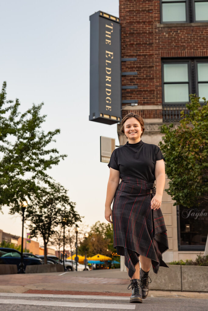 Amelia walking downtown near The Eldridge during edgy senior photos on Mass St in Lawrence, KS
