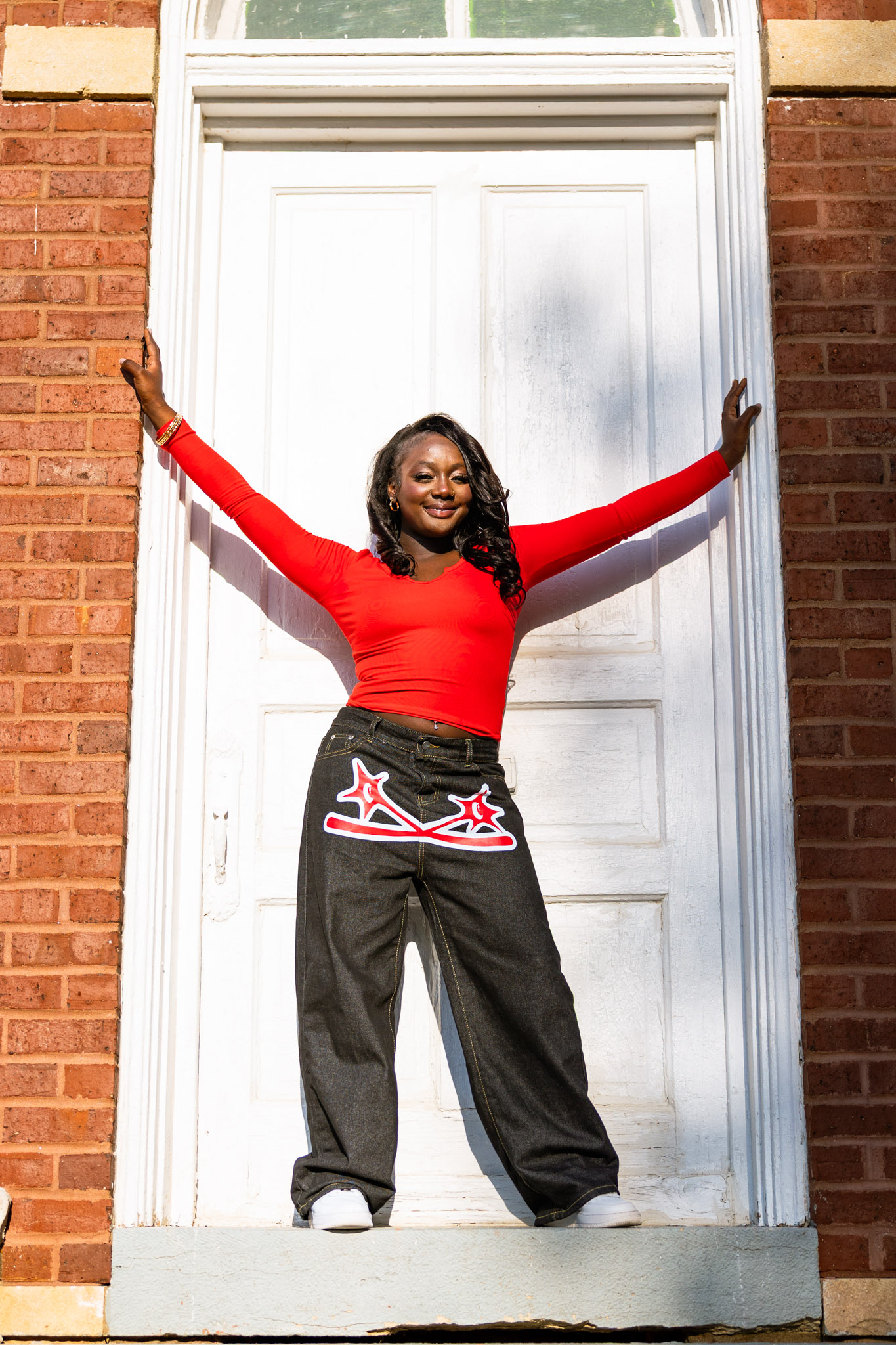 senior portraits in Lawrence KS outdoors brick building confident pose