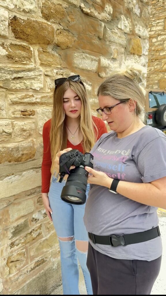 Lawrence KS senior photographer directing a senior through a pose during a guided session